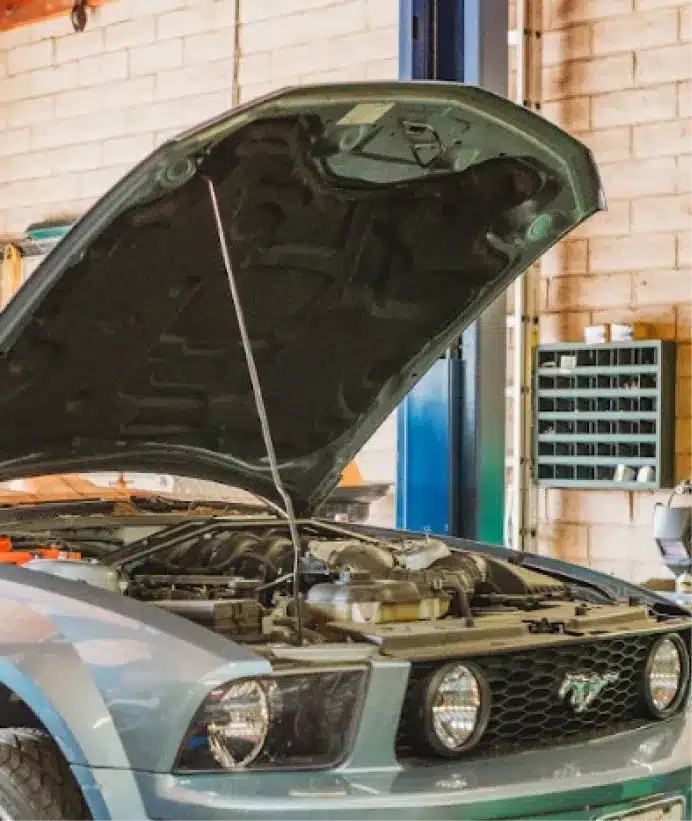 Domestic auto repair, auto repair in Walnut Creek, CA at N Service Auto Repair and Service. A light blue Ford Mustang with its hood open is parked inside an auto repair garage.