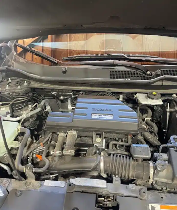Engine repair, auto repair in Walnut Creek, CA at N Service Auto Repair and Service. A close-up view of a Honda engine inside a car, showing various engine components, hoses, and the Honda i-VTEC cover under the open hood.